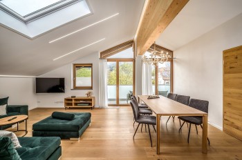 Großzügig wohnen im Schmuckstück – moderner Wohnbereich mit viel Tageslicht, hochwertigen Materialien und Platz für entspannte Urlaubsmomente mit der ganzen Familie.