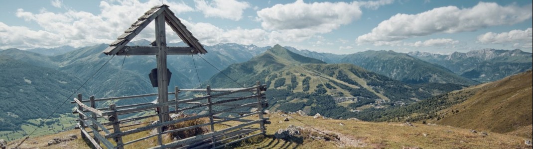 Am Gipfelkreuz des Teuerlnocks genießen Wanderer den herrlichen Blick auf den Katschberg.