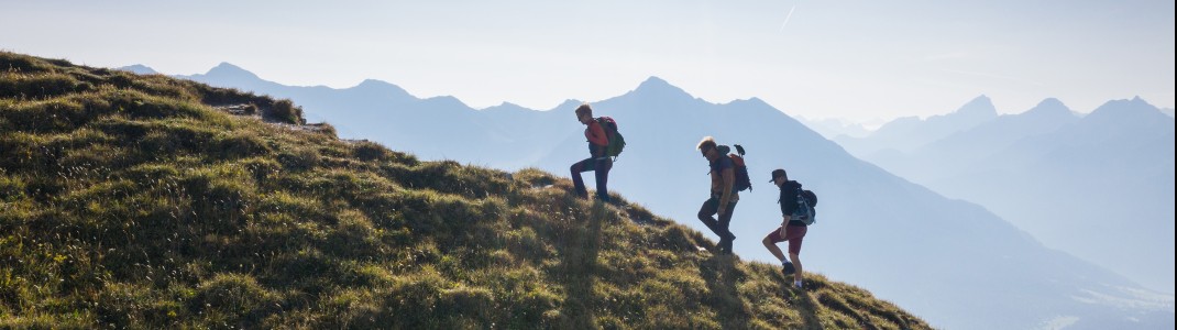 Unterwegs auf dem Grat: Wanderer genießen die spektakuläre Aussicht über die Bergwelt der Lenzerheide.