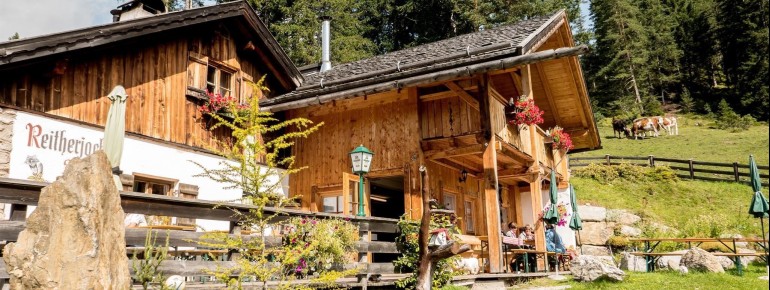 Die gemütliche Reitherjoch Alm lockt mit Tiroler Spezialitäten und einer Sonnenterrasse.