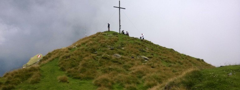 Das Gipfelkreuz des Kochofen umgeben von sattem Grün