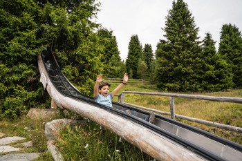 Die Rossalm am Ende des WoodyWalk gehört zu den schönsten Almhütten Südtirols – mit Spielplatz, Floßteich und verfeinerten Almgerichten auf der Sonnenterrasse.