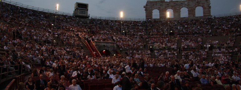 Auf Stühlen und auf den Steinstufen sitzt das Publikum bei Konzerten und Opernaufführungen.