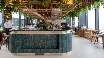 Die stilvolle HighGarden Rooftop Lounge im 49. Stock lädt Gäste ein, bei Signature-Cocktails in eleganter Atmosphäre den Blick über Warschau zu genießen.