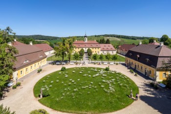 Die barocke Schlossanlage umfasst Herrenhaus, Wirtschaftsgebäude und einen malerischen Landschaftspark.