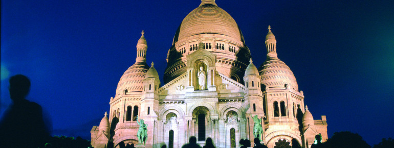 Die Basilika Sacré-Coeur wird bei Dunkelheit beleuchtet.