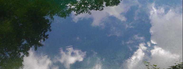 Der Himmel spiegelt sich im klaren Wasser