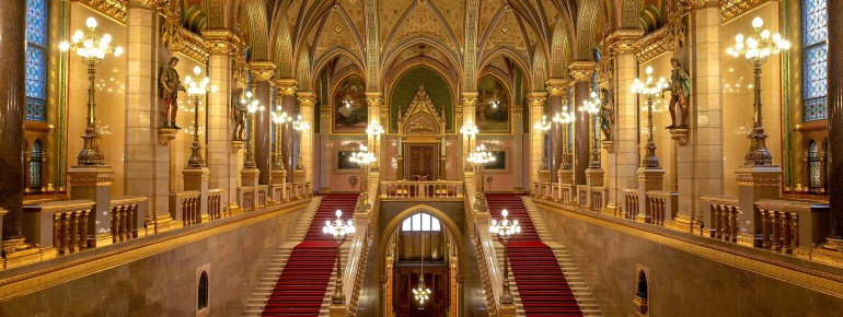 Das prunkvolle Treppenhaus im Inneren des Parlamentsgebäudes beeindruckt mit goldenen Verzierungen, roten Teppichen und neogotischem Dekor