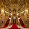 Das prunkvolle Treppenhaus im Inneren des Parlamentsgebäudes beeindruckt mit goldenen Verzierungen, roten Teppichen und neogotischem Dekor