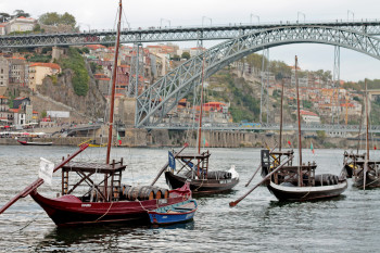 Am Douro-Ufer in Vila Nova de Gaia sieht man Boote mit Portwein-Fässern.