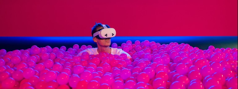 Mit VR-Brille wird das pink leuchtende Bällebad zur digitalen Traumwelt.
