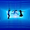 Leuchtende Linien und schwebende Silhouetten lassen den Raum wie einen endlosen Tunnel wirken.