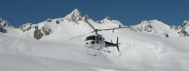 Auf dem Gletscher landender Helikopter