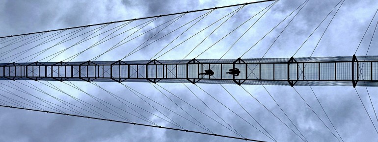 Der Boden besteht aus einem offenen Metallgitter, sodass der Blick jederzeit direkt in die Tiefe möglich ist.