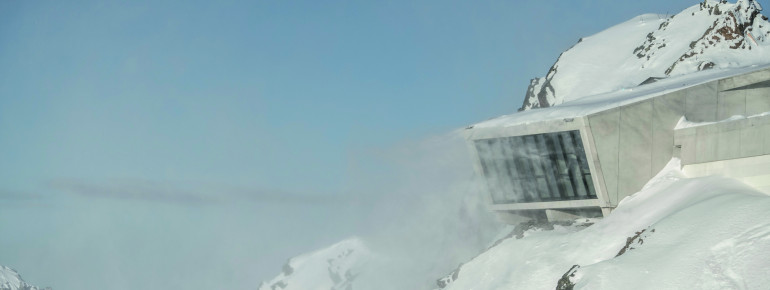 Im Winter aus der Ferne kaum zu erkennen, schmiegt sich der Bau der Erlebniswelt an den Berg.