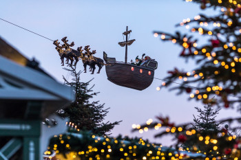 Im Kieler Weihnachtsdorf am Rathausplatz schwebt der Wichtel Kilian mit seiner Kogge, einem Segelschiff, über den Himmel.