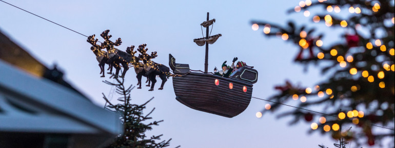 Im Kieler Weihnachtsdorf am Rathausplatz schwebt der Wichtel Kilian mit seiner Kogge, einem Segelschiff, über den Himmel.