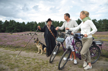Schäferin mit Schäferhund und Pärchen auf Radtour