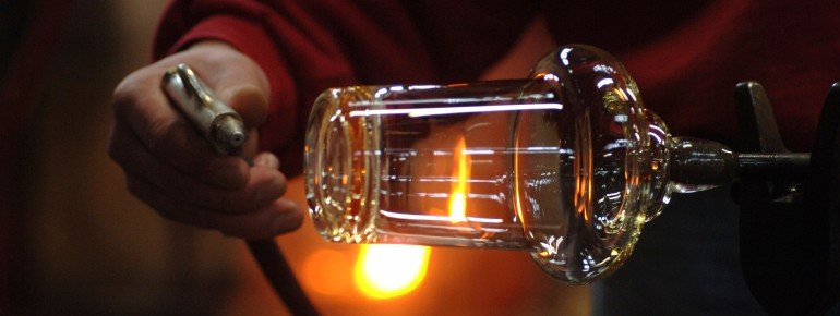 Ein Glasarbeiter beim Abühlen der Glasmasse