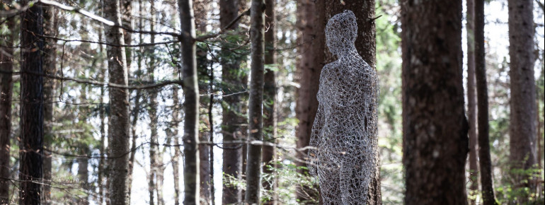 "La donna invisibile" von Cedric Le Borgne zeigt eine transparente Frau, die durch ihre Transparenz mit der Natur verschmilzt.
