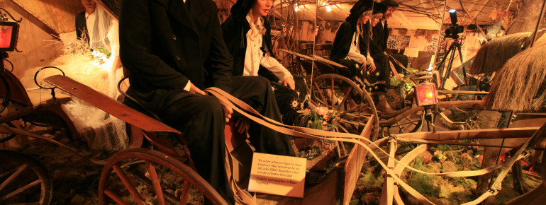 Die Kutschen sind in aufwendig geschmückten Szenerien ausgestellt.