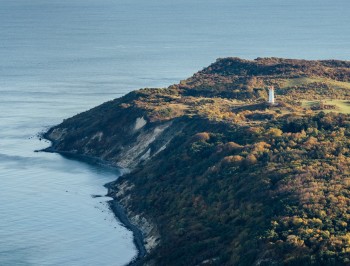 Hoch oben auf dem Schluckswiek thront der Leuchtturm Dornbusch über der Küstenlandschaft im Norden Hiddensees.