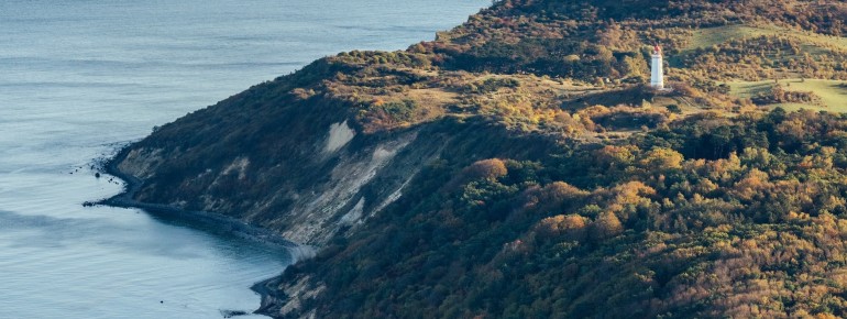 Hoch oben auf dem Schluckswiek thront der Leuchtturm Dornbusch über der Küstenlandschaft im Norden Hiddensees.
