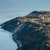 Hoch oben auf dem Schluckswiek thront der Leuchtturm Dornbusch über der Küstenlandschaft im Norden Hiddensees.