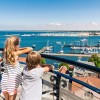 Vom Warnemünder Leuchtturm genießt du einen weiten Blick über Strand, Promenade und Ostsee.