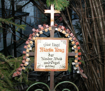 Das Grabkreuz mit der Inschrift „Hier liegt Martin Krug, der Kind, Weib und Orgel schlug“ stammt aus der Tiroler Ortschaft Wiesing.