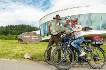 Radfahrer mit einem Ranger vor dem Nationalparkzentrum.