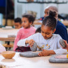 In der Steinzeitwerkstatt können Kinder unter anderem wie früher Brot backen.