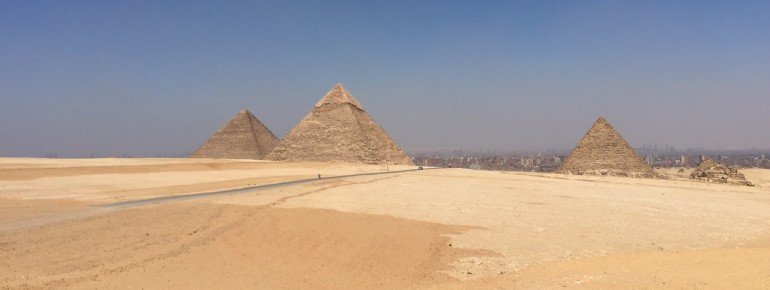 Die drei großen Pyramiden von Gizeh - im Hintergrund die Stadt Kairo