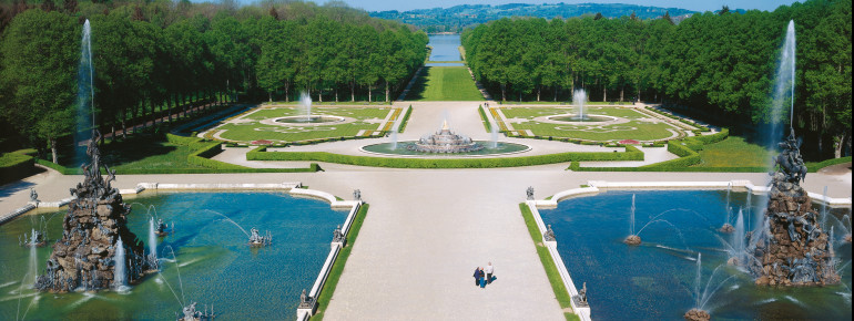 Blick vom Schloss auf den weitläufigen Schlosspark. Ganz am Ende des Park sieht man das Ufer des Chiemsees.