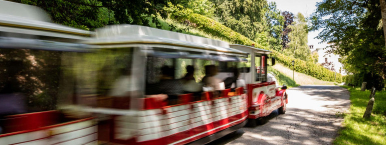 Mit dem Bummelzug Tratzberg-Express kannst du nach oben zum Schloss fahren.