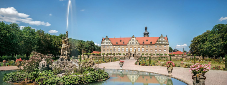 Schlossgarten mit dem prunkvollen Renaissanceschloss im Hintergrund