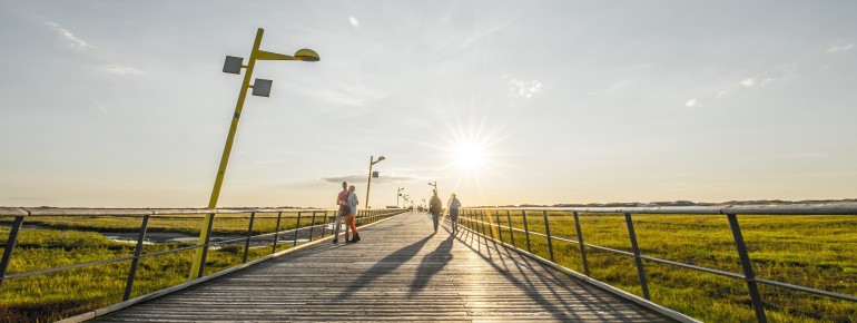 Die barrierefreie Holzkonstruktion führt vom Ortsteil Bad über Salzwiesen, Dünen und Priele mitten durch den Nationalpark Schleswig-Holsteinisches Wattenmeer.