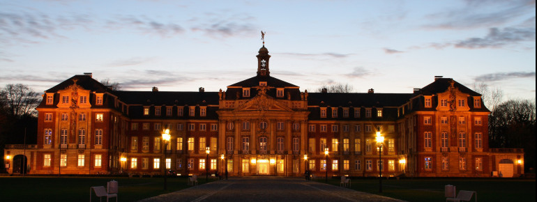 Das Schloss Münster erstrahlt in der Abenddämmerung.