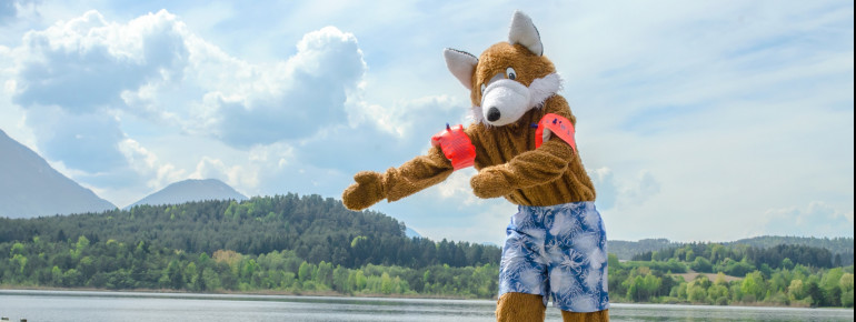 Das Parkmaskottchen Reiny Reineke empfiehlt nach einem Besuch in der Walderlebniswelt ein Bad im Klopeiner See.