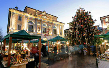 Vor dem Rathaus in der Altstadt von Lugano erwarten dich einige Stände und ein großer Weihnachtsbaum.
