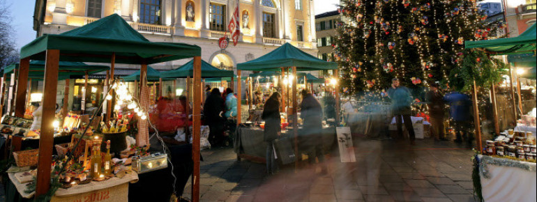 Vor dem Rathaus in der Altstadt von Lugano erwarten dich einige Stände und ein großer Weihnachtsbaum.