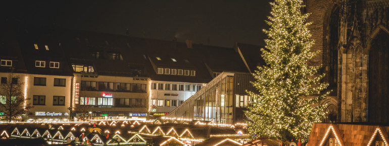 In der Mitte des Platzes befindet sich ein großer geschmückter Weihnachtsbaum.