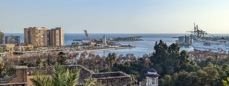 The fortress offers sweeping views of lush greenery, the bustling harbour city, the town hall, and the container port.