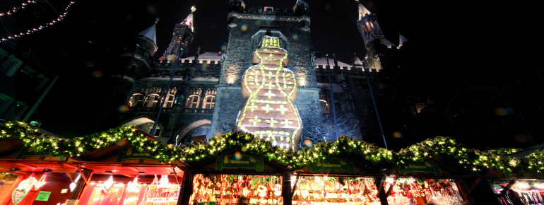 A large gingerbread man shines down from the city hall.