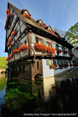 The tilting house right by river Blau.