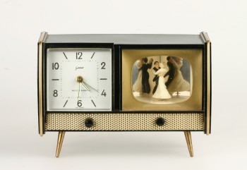 A TV clock with decorative figures from the years around 1960.