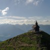 The mountain chapel sits majestically atop the summit, overlooking the vast Inn Valley.
