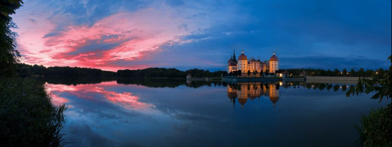 The palace is surrounded by a large pond.