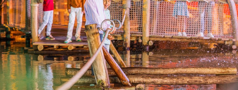 Little pirates bravely pull themselves across the pirate lake on a raft.