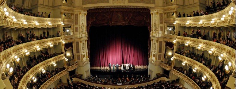 The audience is distributed among four tiers and the stalls area.